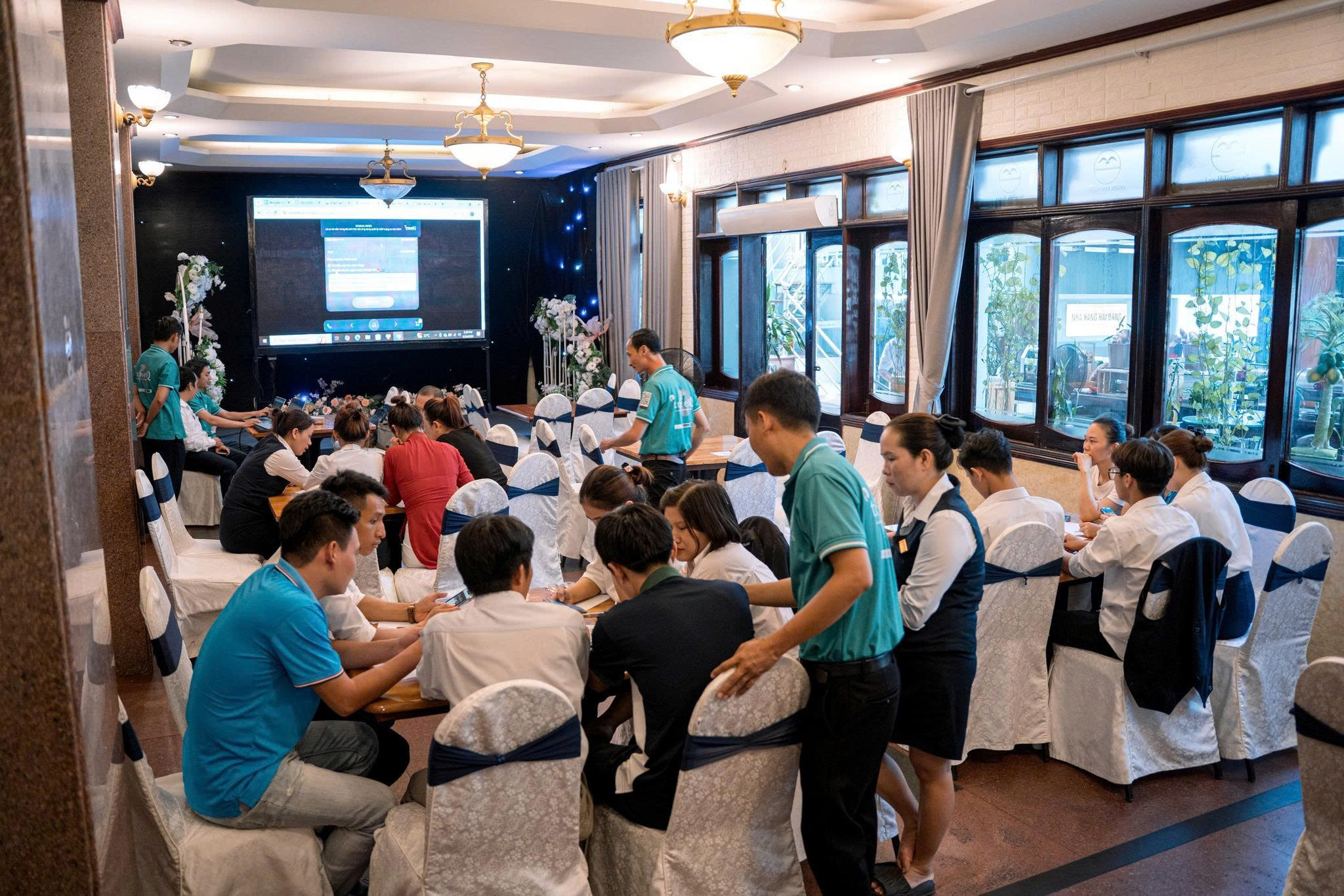 Hình ảnh nhân viên Holitech đang hỗ trợ khách hàng sử dụng app Travel Restaurant